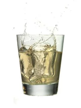 Ice cube splashed into the glass of whiskey Stock Photos