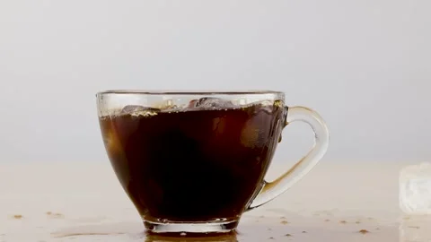 Ice Cube Splashing into Glass Cup of Black Coffee 動画素材 341666954