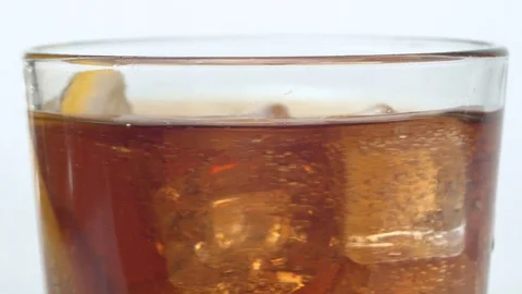 Ice cubes and lemon slice in the glass of cola Stock Footage 124038982