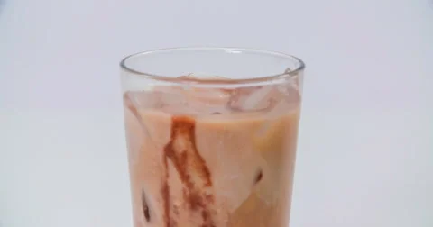 Ice cubes are falling into a chocolate drink Vídeos de archivo 64932317