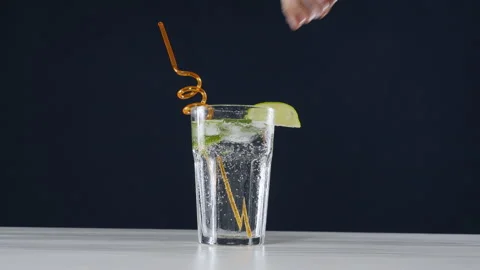 Ice cubes are placed in a cold mojito cocktail with lime and soda Stock Footage 178477343