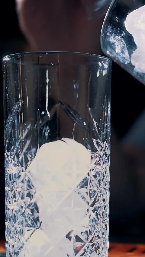 Ice cubes. bartender puts ice cubes into a glass. close-up. bartender is putting Stock Footage 317437496