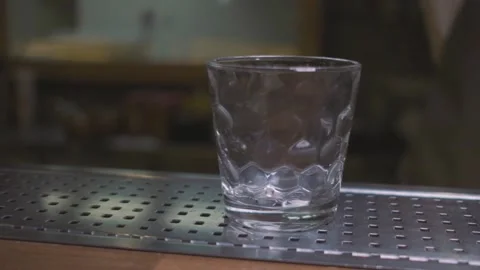 Ice cubes being thrown into an empty glass close-up in slow motion Stock Footage 141187499
