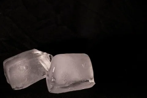 Ice cubes. Black background. Cold. Frozen. Water droplets. White and black. Stock Photos