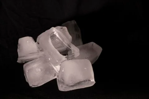 Ice cubes. Black background. Cold. Frozen. Water droplets. White and black. Stock Photos