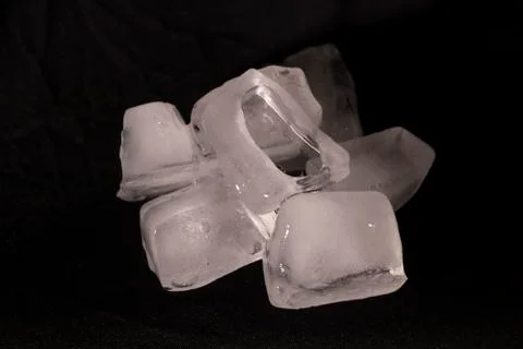 Ice cubes. Black background. Cold. Frozen. Water droplets. White and black. Stock Photos