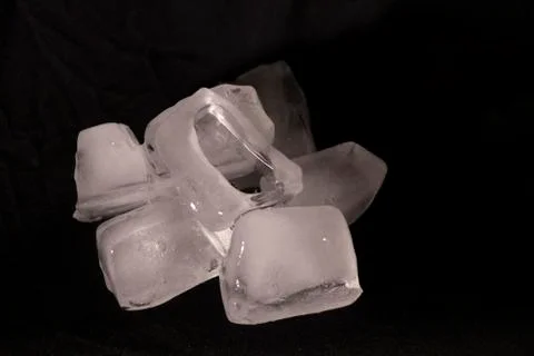 Ice cubes. Black background. Cold. Frozen. Water droplets. White and black. Stock Photos