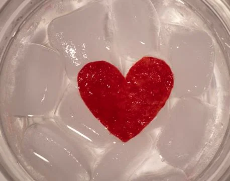 Ice cubes. Black background. Cold. Frozen. Water droplets. Red heart in a bow Stock Photos