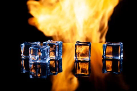 Ice cubes on a black background in flames Stock Photos