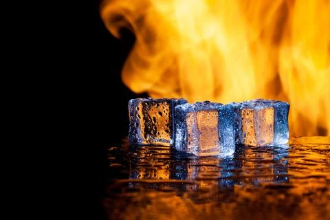 Ice cubes on a black background in flames Stock Photos