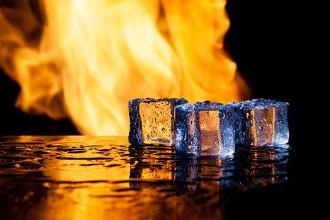 Ice cubes on a black background in flames Stock Photos