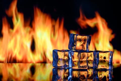Ice cubes on a black background in flames Stock Photos