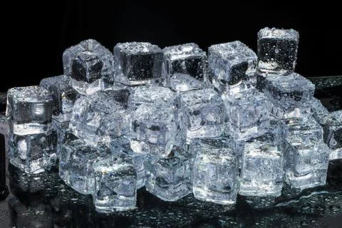 Ice cubes on black wet table. Selective focus. Stock Photos