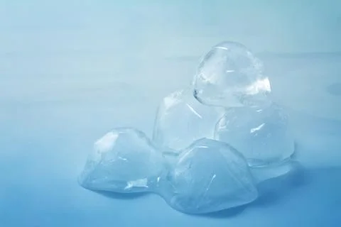 Ice cubes on blue background Stock Photos