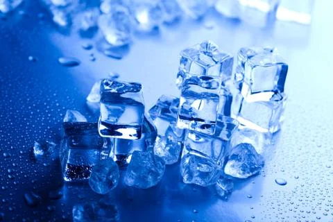 Ice cubes on blue background Stock Photos