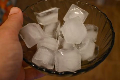 Ice cubes in a bowl held by hand Фото