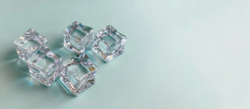 Ice cubes on a bright blue background. Summer concept Stock Photos