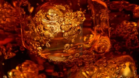 Ice cubes with bubbles in a rotating glass of cola. Abstract super close-up shot Stock Footage 128798554