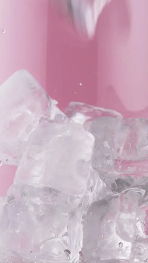 Ice cubes drop into clear glass, splashes sparkle, prep for iced drinks, bar Stock Footage 317929152