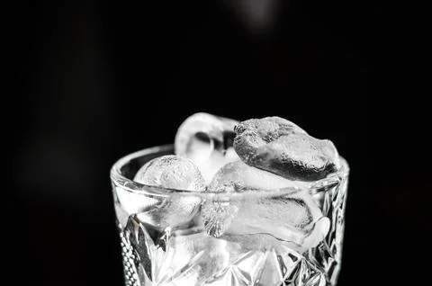 Ice cubes in an empty glass on a dark background, front view with details 스톡 사진