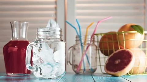 Ice cubes fall into empty mason jar, slow motion. Stock Footage 87388050