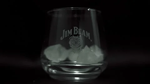 Ice cubes fall into an empty whiskey glass in slow motion Stock Footage 158515640