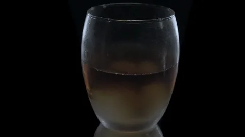 Ice cubes fall into a glass on black background. Slow motion. Video stock 125422292