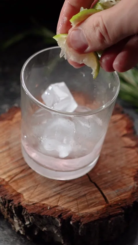Ice cubes fall into a glass with lime and rosemary and topped with soda. The Video stock 279915125