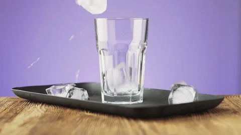 Ice cubes fall into a glass, slow motion. Stock Footage 92323334