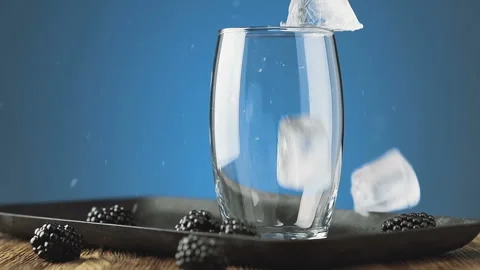 Ice cubes fall into a glass, slow motion. Cocktail concept. Stock Footage 92622298