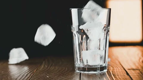 Ice cubes fall into a glass, slow motion. Cocktail concept. Stock Footage 93041281