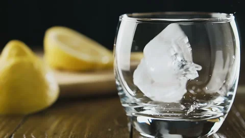 Ice cubes fall into a glass, slow motion. Cocktail concept. Stock Footage 93041337