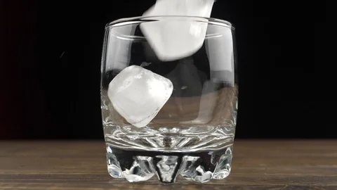 Ice cubes fall into a glass, slow motion. Cocktail concept. Video stock 110909539