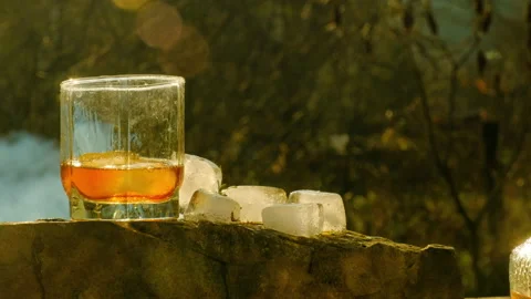 Ice cubes fall into a glass of whiskey Stock Footage 164376769