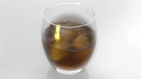 Ice cubes fall into a glass on white background. Slow motion. Cocktail concep Video stock 125379326