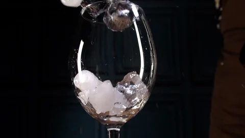 Ice cubes fall into a wine glass. slow motion Stock Footage 114495379