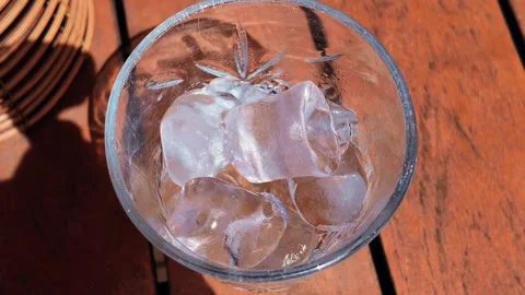 Ice Cubes falling down in empty transparent glass. Make a fresh drink. 스톡 동영상 337349783