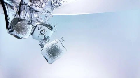 Ice cubes falling down splash into water on white background Stock Footage 76240375