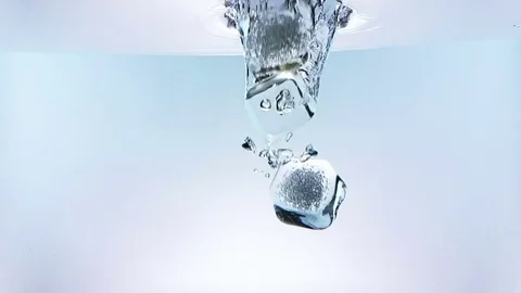Ice cubes falling down splash into water on white background, shot slow motion Video stock 77358517