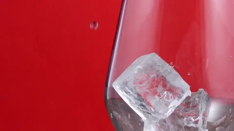 Ice Cubes Falling Into A Glass on a red background Slow motion 300 fps Stock Footage 151622676