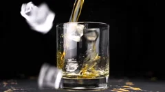 Ice cube falling into whisky glass – License Images – 11039807
