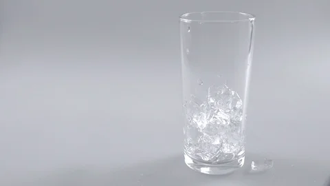 Ice cubes falling in glass on white background Stock Footage 103239843
