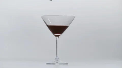 Ice cubes falling into red wine, Ultra Slow Motion Stock Footage 86579200