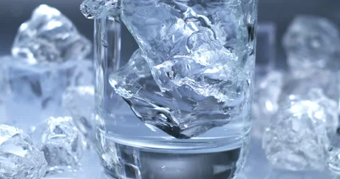 Ice cubes falling with splashing water drops in glass with pure fresh liquid Stock Footage 269946863