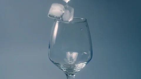 Ice cubes falls to the empty glass in slow motion, adding ice to the drink, food Stock Footage 117622950