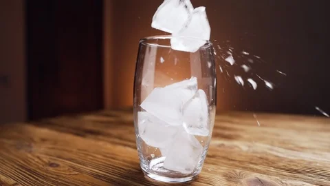 Ice cubes falls into glass, fixed-point follow focus. Video stock 129141786