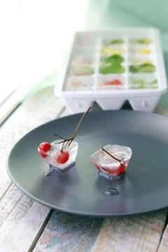 Ice cubes with mint, lemon and red berries in a tray for making drinks Stock Photos