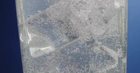 Ice cubes in a misted glass with drops of ice water close-up macro. Refreshing Stock Footage 243220734