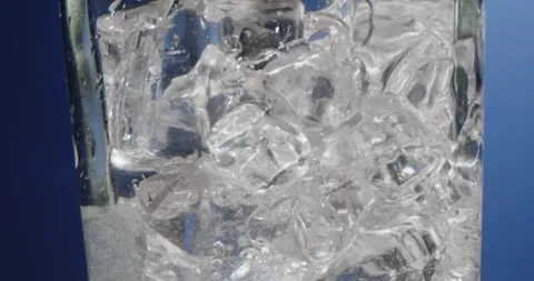 Ice cubes in a misted glass with drops of ice water close-up macro. Refreshing Vidéo 243220849