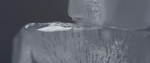 Ice cubes rotate on a light background macro shot Stock Footage 106007365